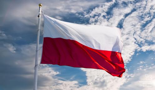 Biało-czerwona flaga, powiewajaca na tle nieba.