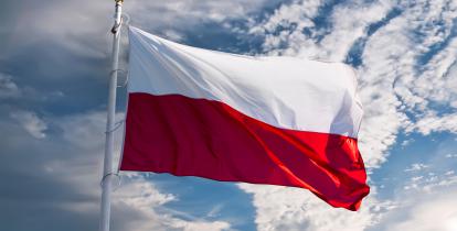 Biało-czerwona flaga, powiewajaca na tle nieba.