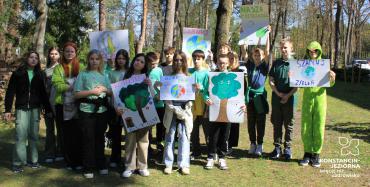 Grupka dzieci, w rękach trzymają kolorowe plakaty z ekologicznymi hasłami z okazji Dnia Ziemi. 