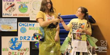 Trzy dziewczynki w strojach wykonanych z materiałów przeznaczonych do recyklingu. 